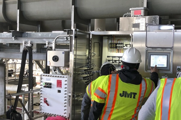 People in safety gear looking at a control hub