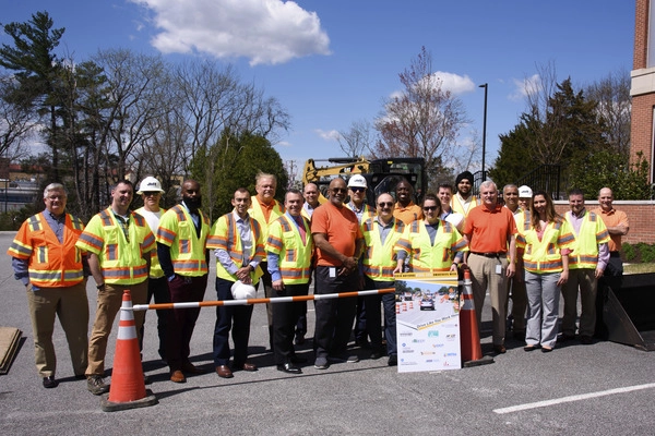 People wearing safety vests and hats smiling