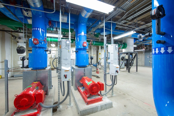 Large blue pipes running up and across a ceiling