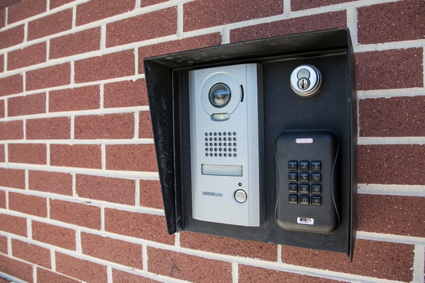 Camera and security keypad on a brick wall